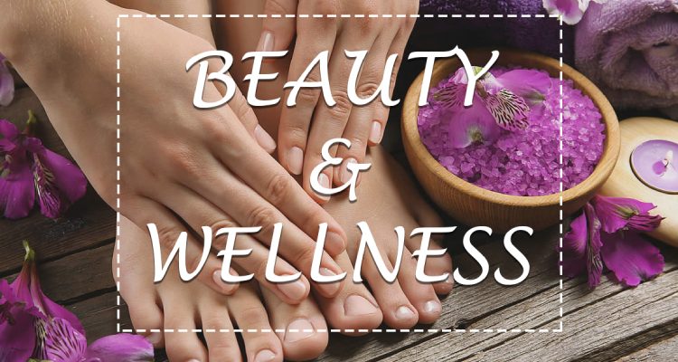 An image showing hands, legs and spa products like candle, lavender flowers and towels